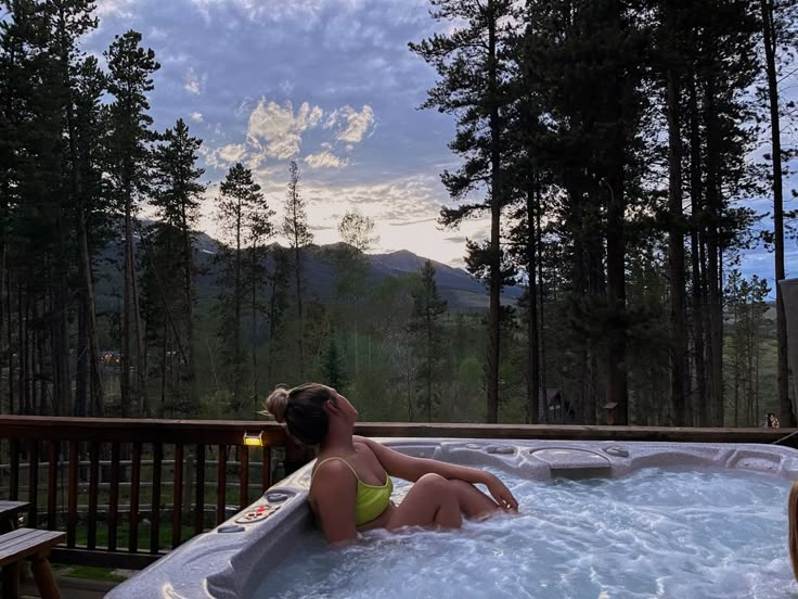 a woman sitting in an outdoor hot tub