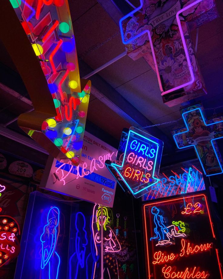 neon signs are hanging from the ceiling in a room filled with other decorations and lights