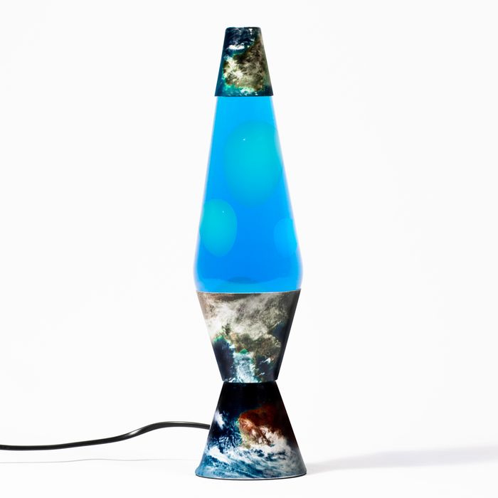 a blue vase sitting on top of a table next to a black cord and plugged in