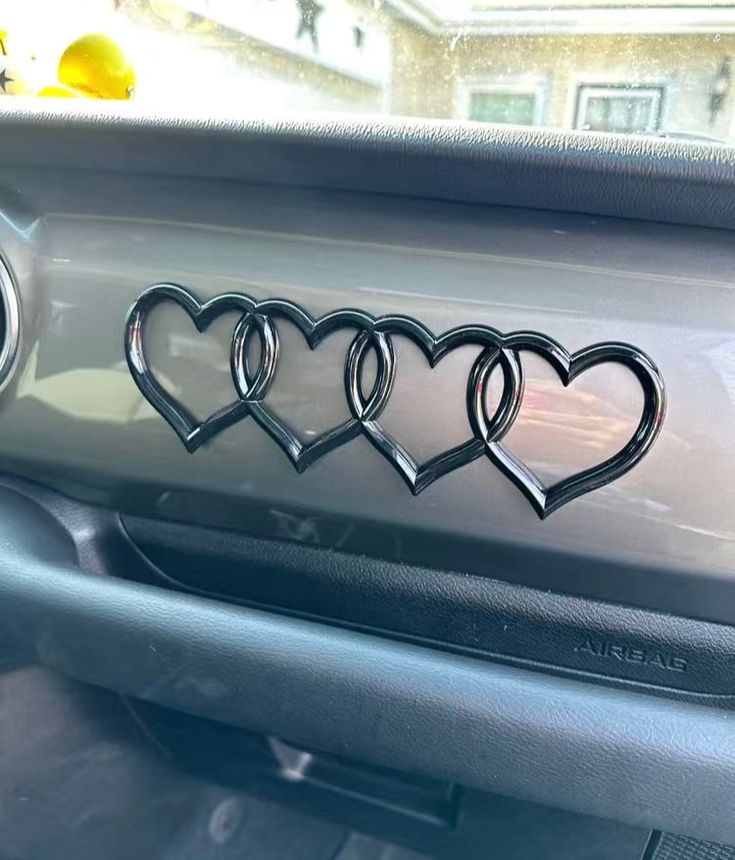 four heart shaped emblems on the dashboard of a car