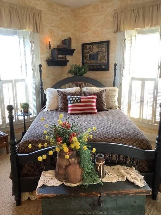 a bedroom with a large bed and flowers on the end table in front of it