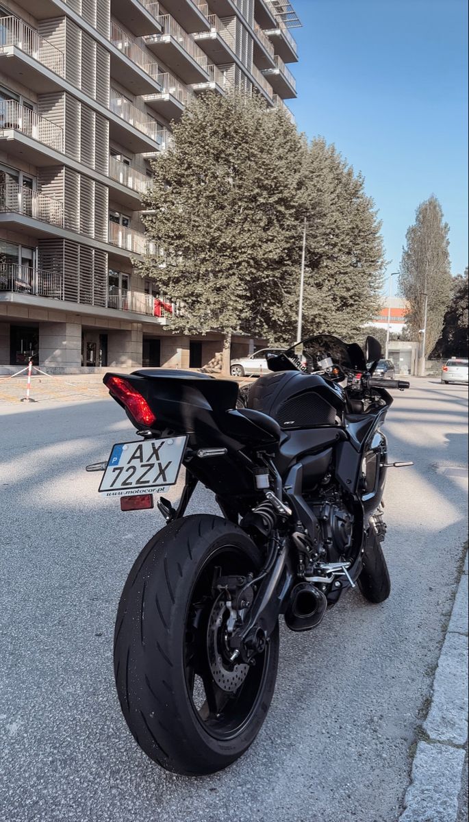 a black motorcycle parked in front of an apartment building