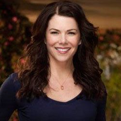 a woman with long dark hair smiling at the camera