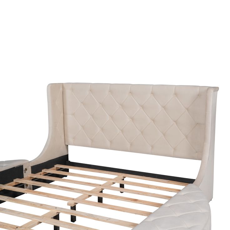 an upholstered bed frame with wooden slats and buttons on the headboard