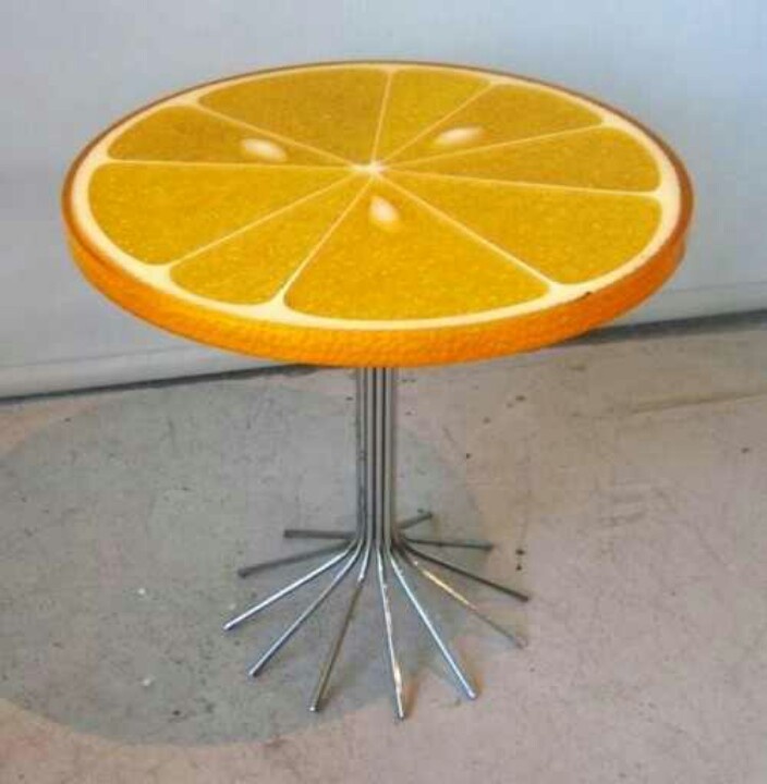 an orange slice sitting on top of a metal stand with four legs and two ends