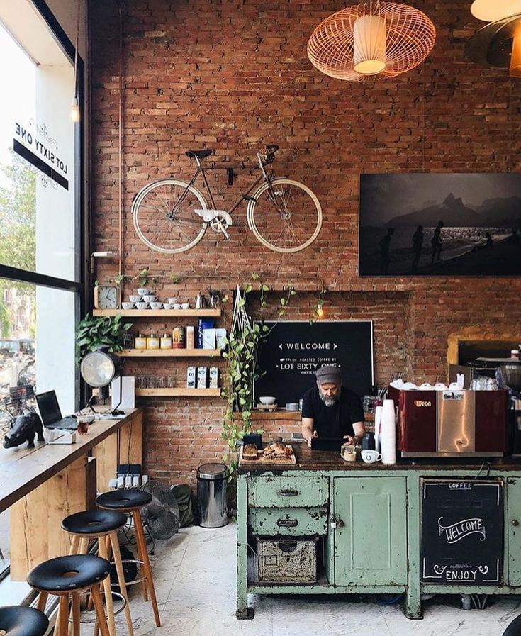 a bike mounted to the side of a brick wall next to a bar with stools