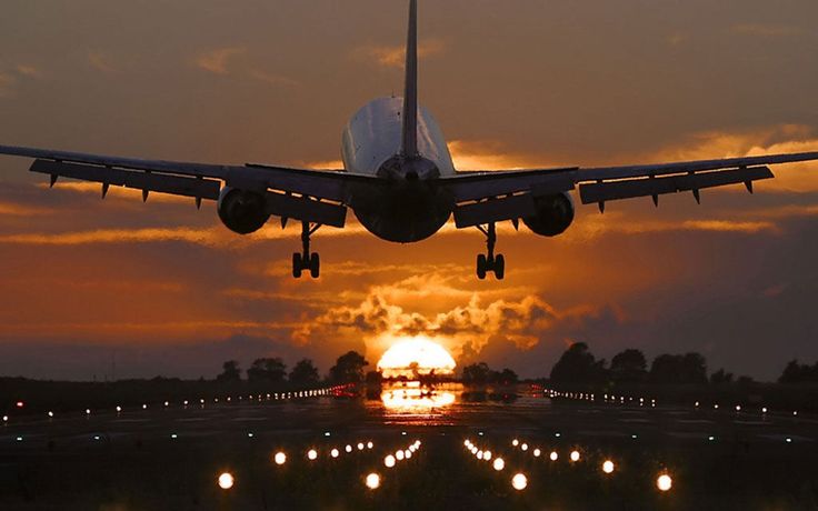 an airplane is taking off into the sunset