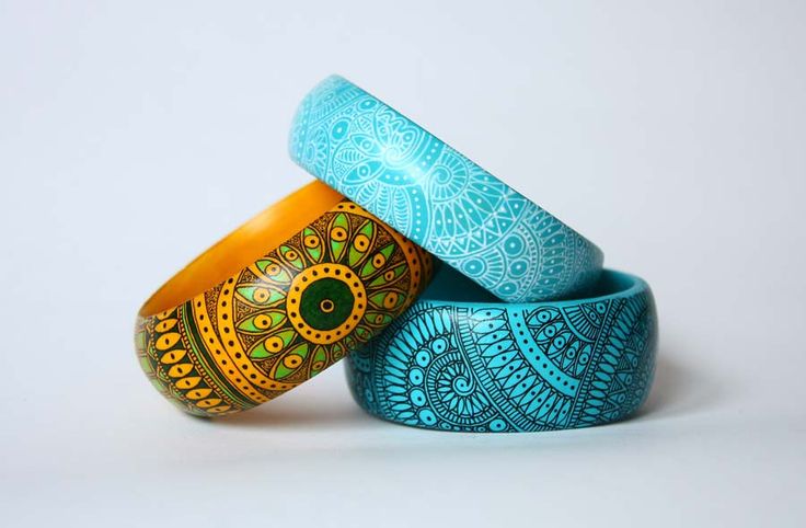 three colorful rings with designs on them sitting in front of a white background or wall