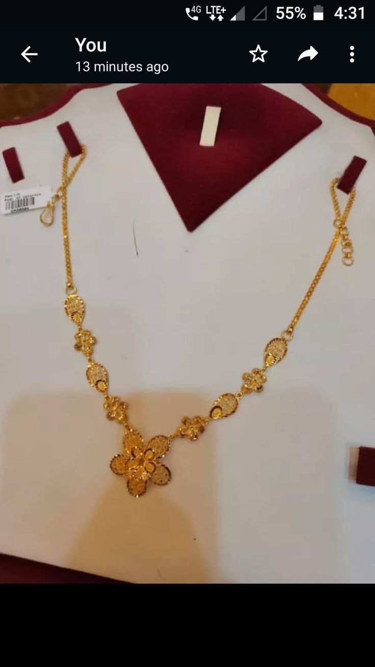 a gold necklace is displayed on a mannequin