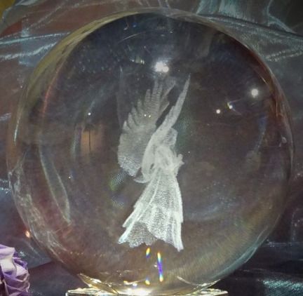 a clear glass ball with a white angel on it