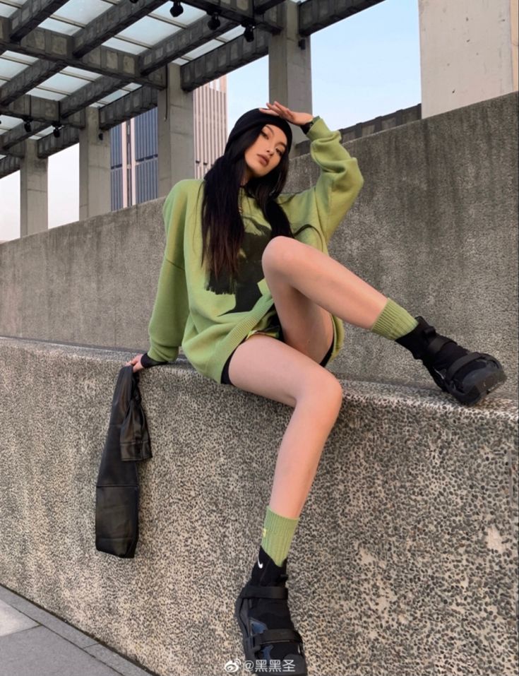 a woman sitting on top of a cement wall