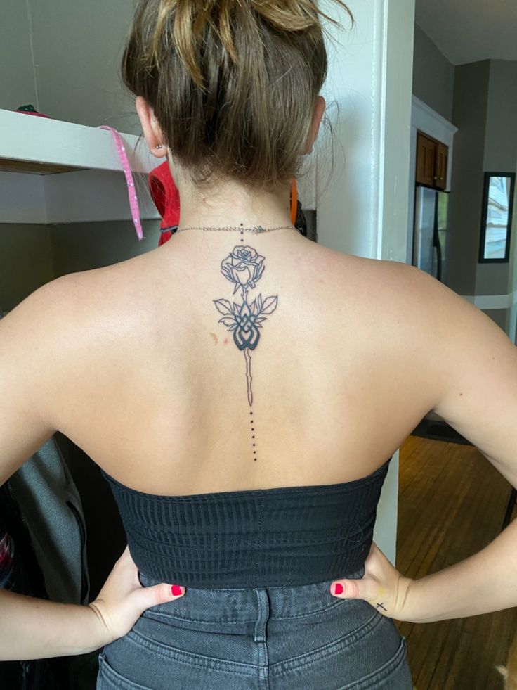 a woman with a flower tattoo on her back