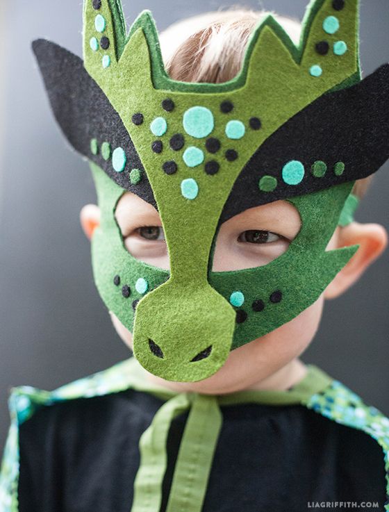 a young boy wearing a green and black mask