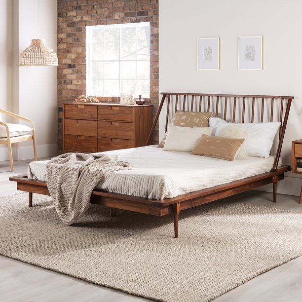 a bed sitting in a bedroom next to a wooden dresser and lamp on top of a rug