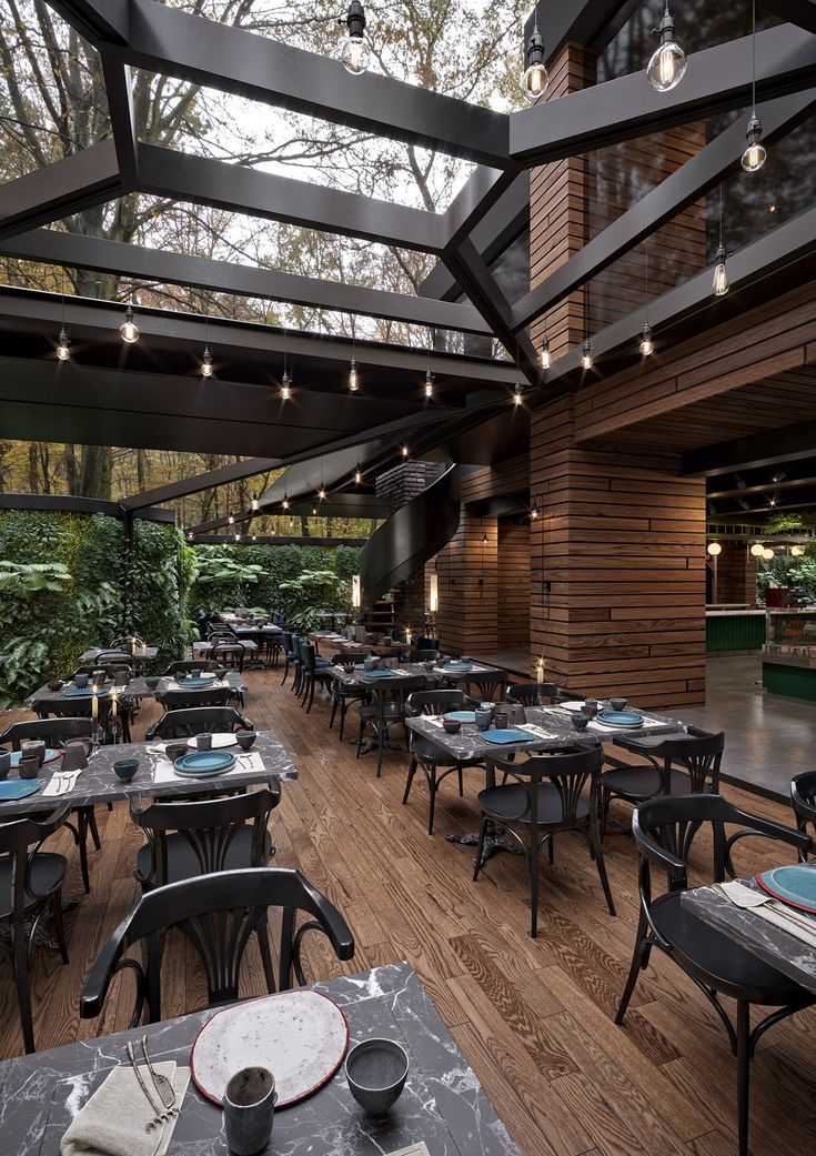 an empty restaurant with tables and chairs set up for dinner in the middle of it