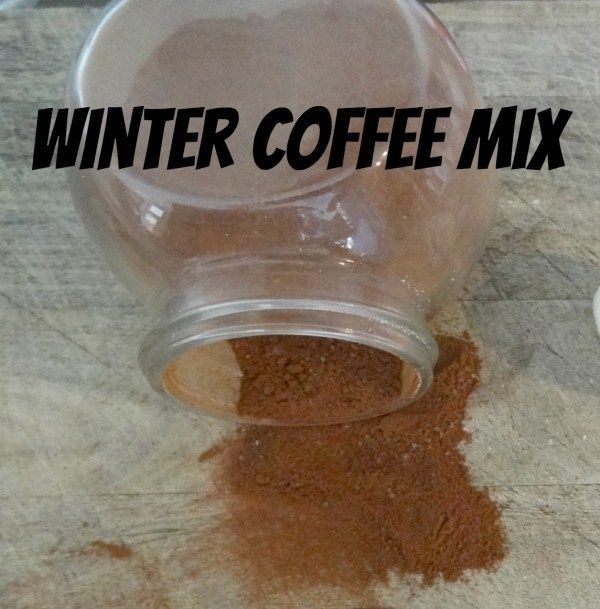 a glass jar filled with coffee sitting on top of a counter next to a cup