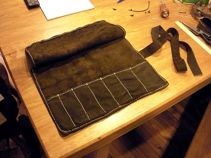 a wooden table topped with lots of crafting supplies next to a phone and keyboard