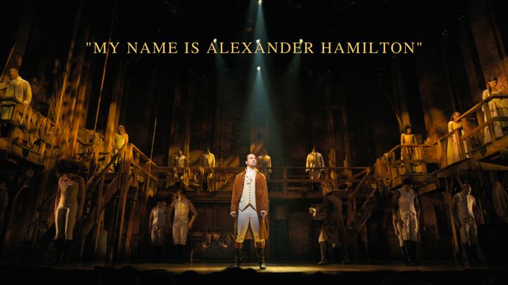 a man standing on top of a stage with lots of people in the back ground