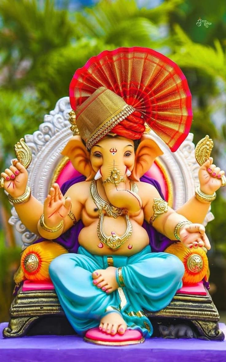 an elephant statue sitting on top of a purple platform in front of a colorful background