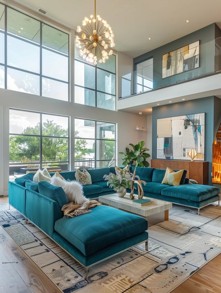 a living room filled with blue couches and lots of glass windows on top of it