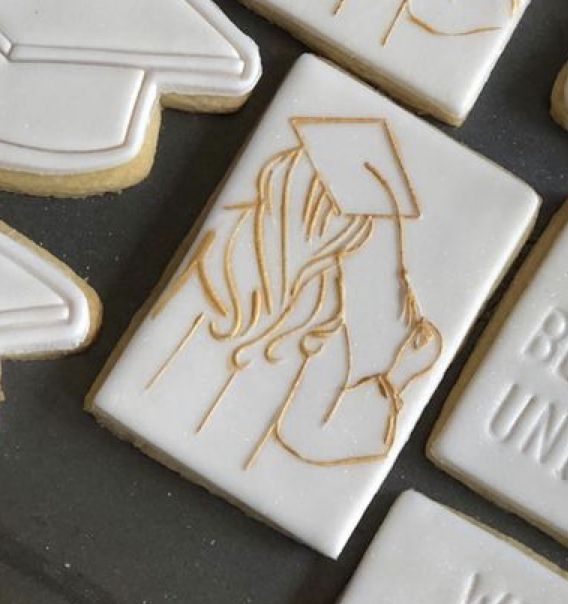 some cookies that have been decorated to look like graduation caps and gowns on them