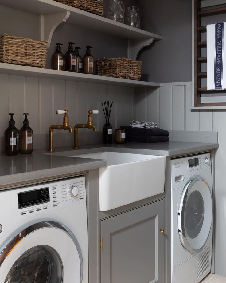 a washer and dryer in a small room with shelves above the washer