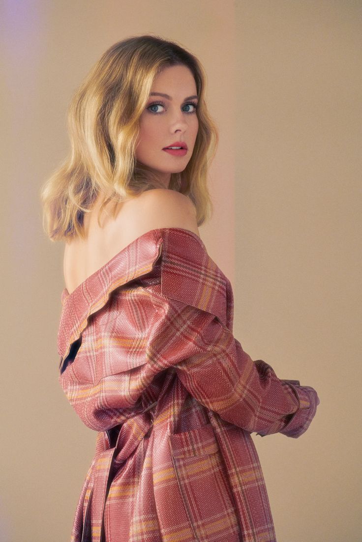 a woman with blonde hair and blue eyes wearing a pink plaid off the shoulder dress