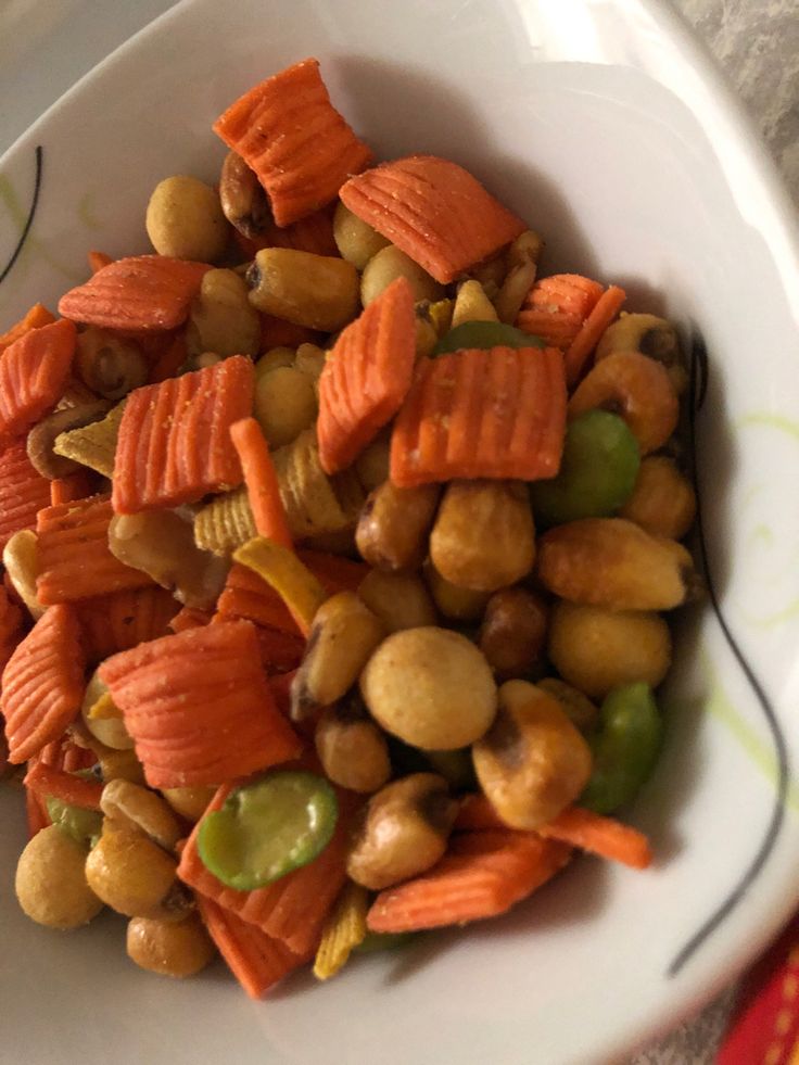 a white bowl filled with carrots and chickpeas on top of a table