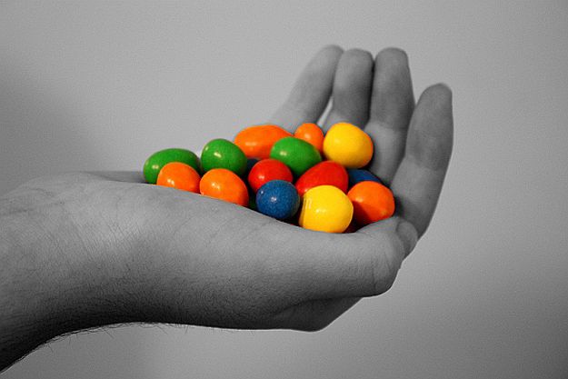 a person's hand holding a handful of gummy balls in black and white