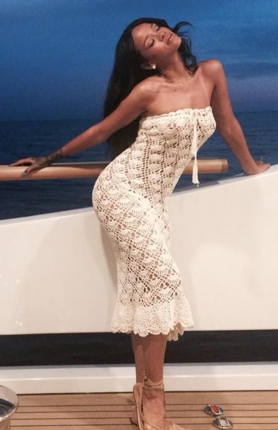 a woman standing on top of a boat next to the ocean with her arms outstretched