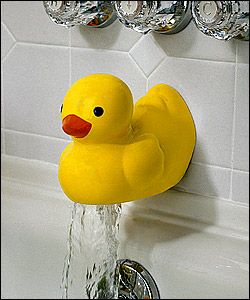 a yellow rubber ducky sitting on top of a faucet