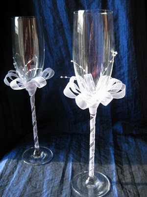 two wine glasses sitting next to each other on top of a blue cloth covered table