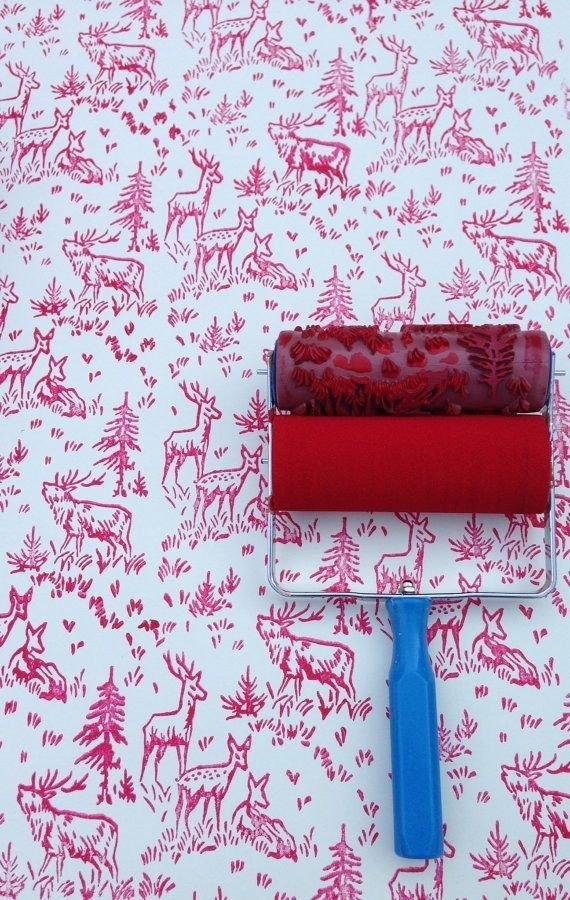 a red and white wallpaper with a paint roller on top of it next to a blue brush