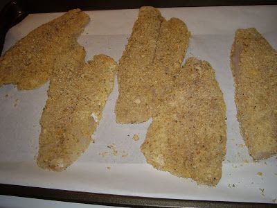 four pieces of chicken sitting on top of a white paper lined baking sheet, ready to go into the oven