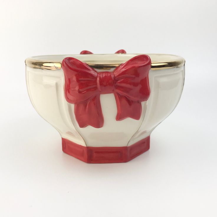 a white and red bowl with a bow on it