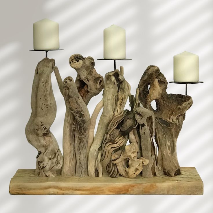 a group of driftwood pieces with candles on them sitting on top of a table