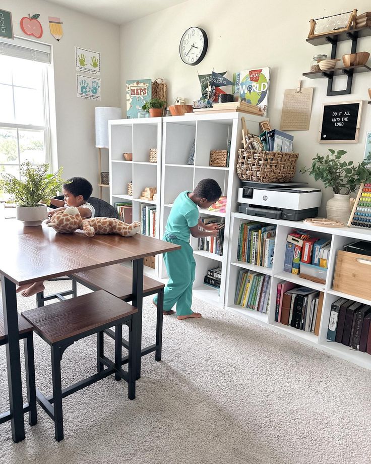 two children are playing in the playroom with bookshelves and shelves full of toys