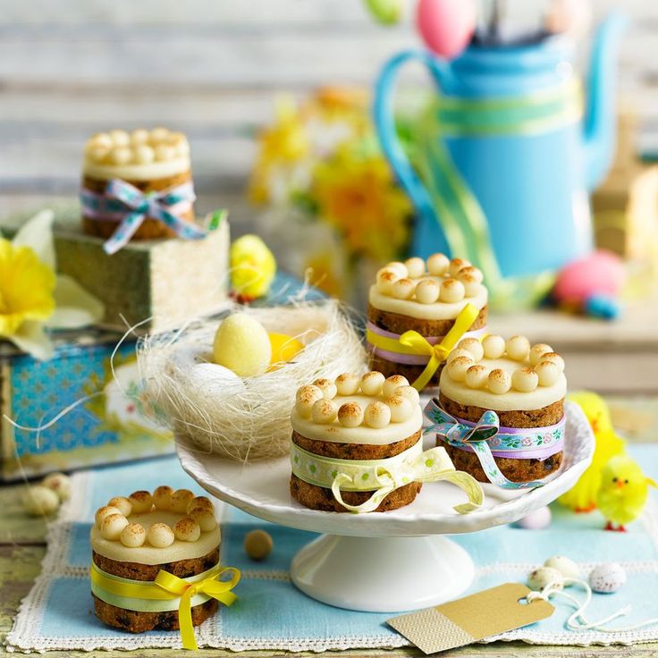 small cakes and candies on a plate with easter decorations around the table in the background