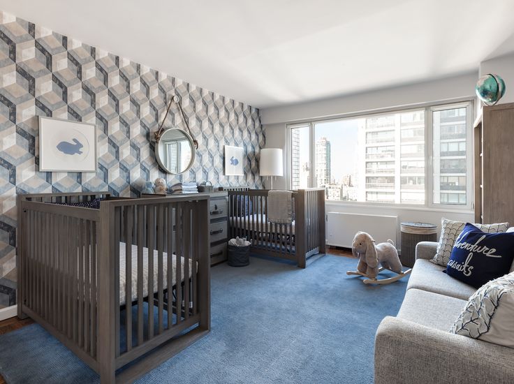 a baby's room with blue carpet and wallpaper