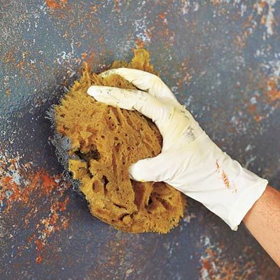 a person wearing white gloves is cleaning rust on the ground