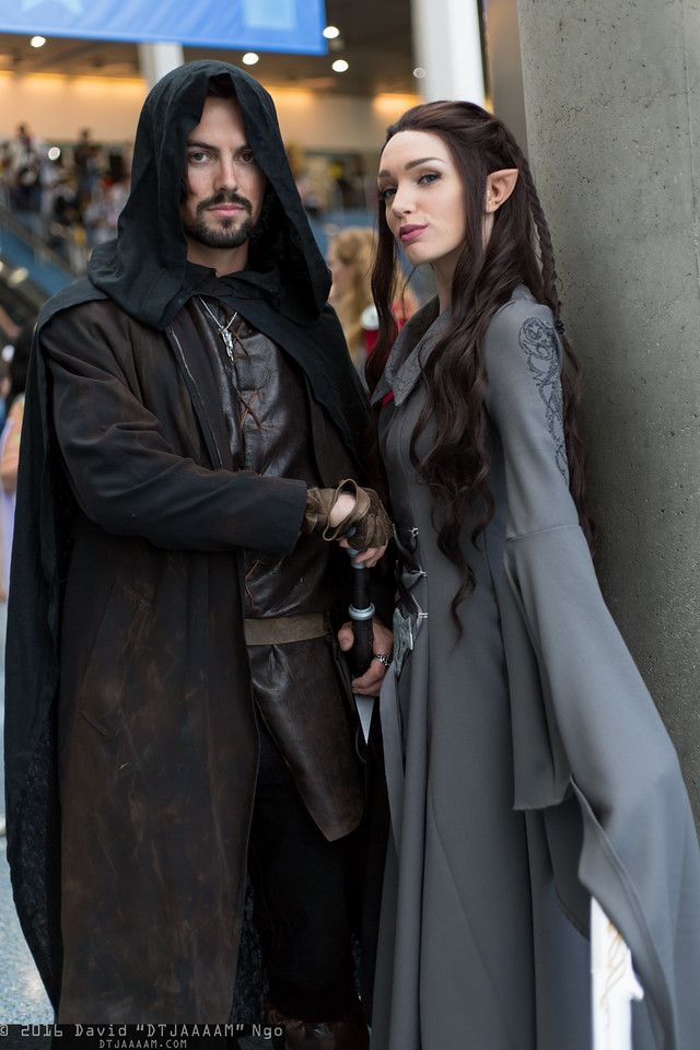 a man and woman dressed up in medieval costumes standing next to each other on the street