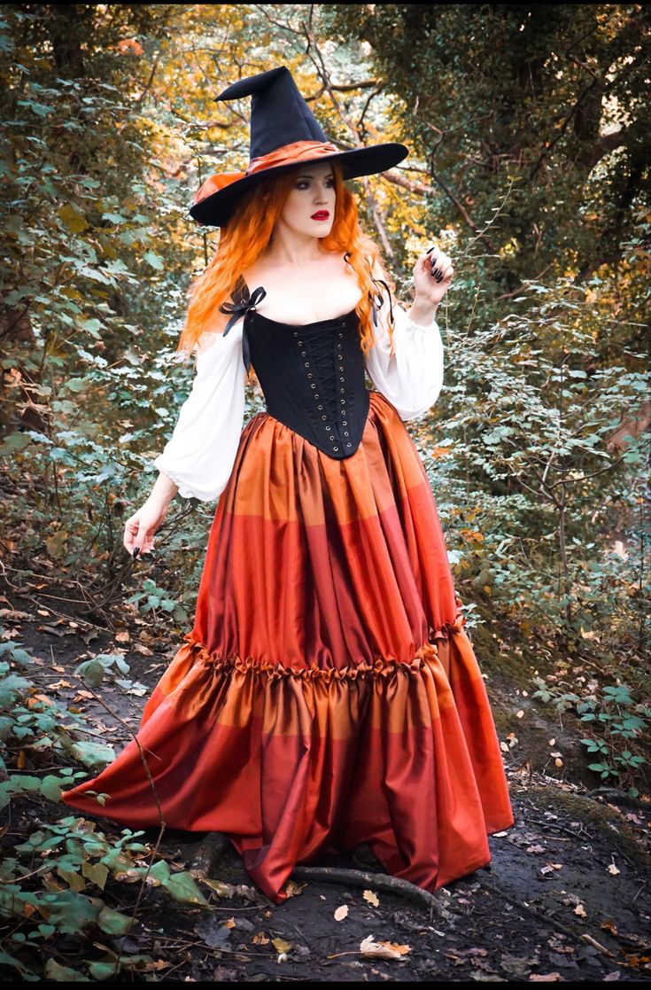 a woman dressed in an orange and black dress with a witch hat on her head