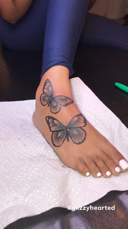 a woman with a butterfly tattoo on her foot