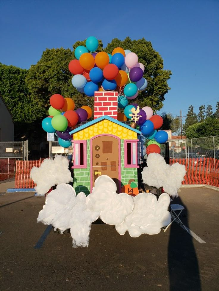 a house made out of balloons in the parking lot