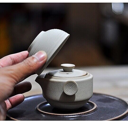 a person is holding a piece of paper over a stove top burner with the lid open