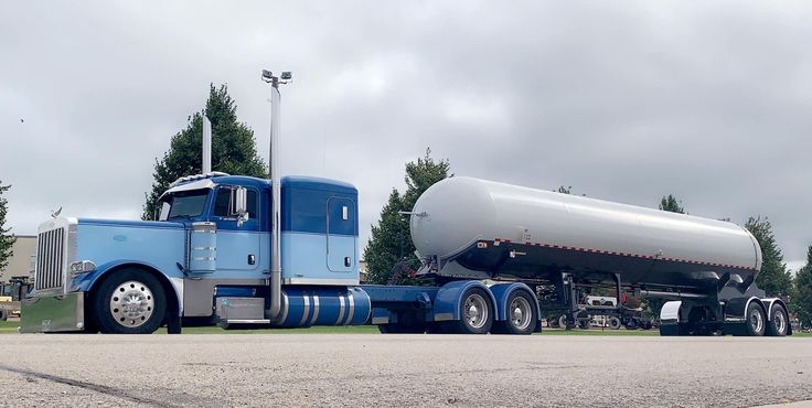 a blue semi truck with a tanker on the back