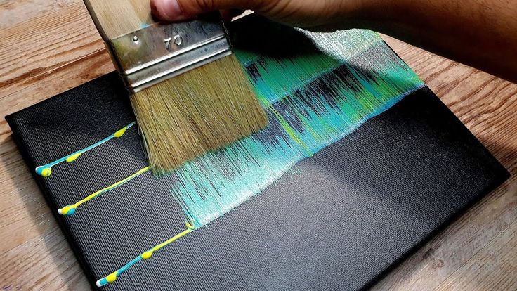 a person using a paint brush on a piece of fabric