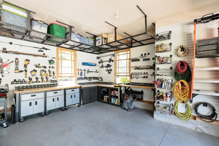 a garage filled with lots of tools and equipment on the wall, including shelves full of items