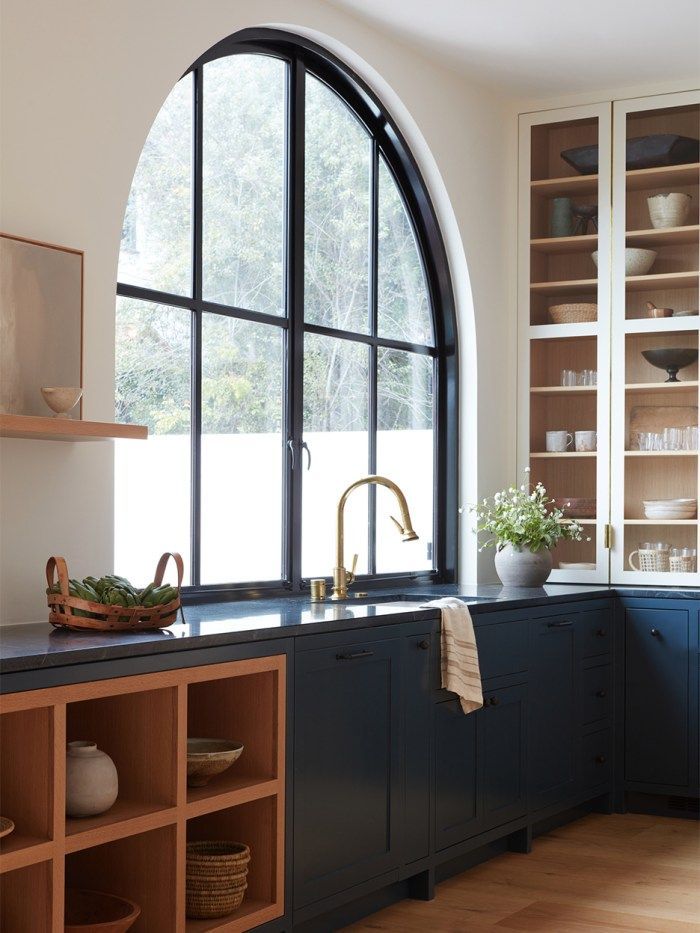 a large arched window in a kitchen next to a sink