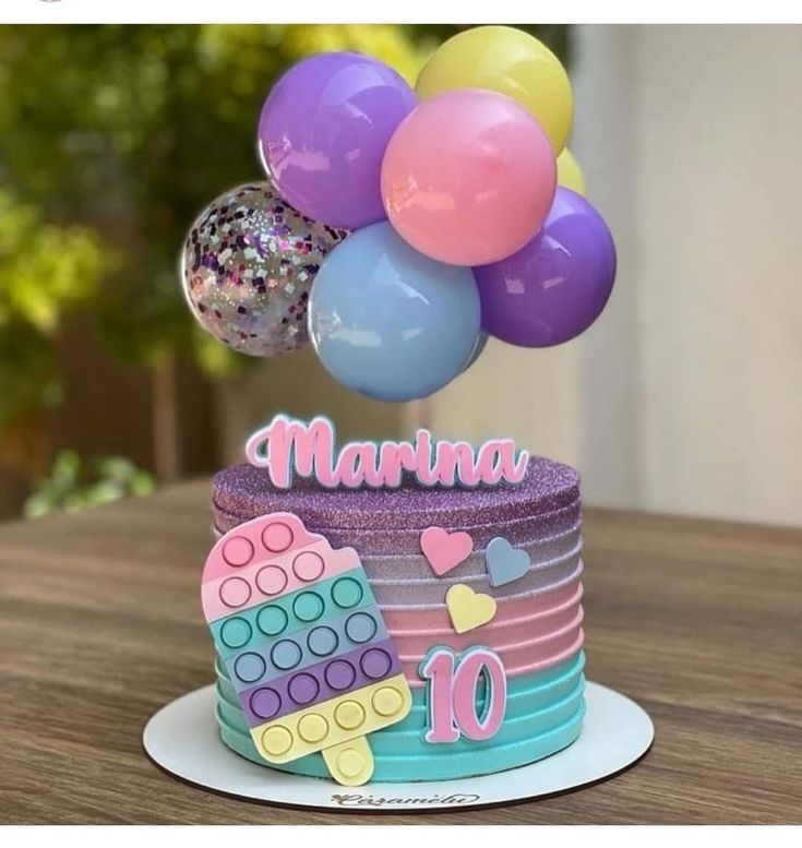 there is a birthday cake with balloons on it and the name marina written on top